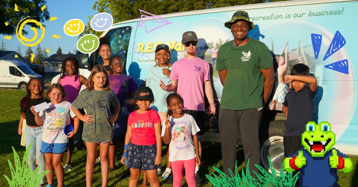 Staff and kids taking a photo in front of the R.E.C. Van